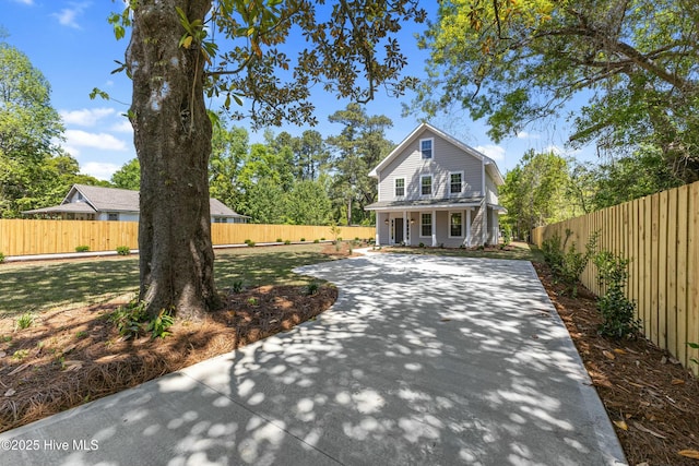 traditional-style house with a porch and fence private yard