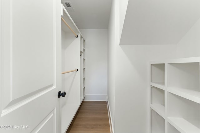 walk in closet with visible vents and wood finished floors