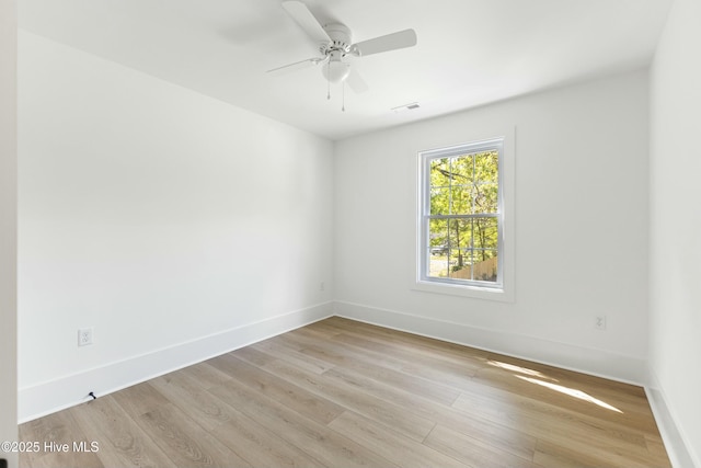 spare room featuring visible vents, baseboards, light wood-type flooring, and ceiling fan