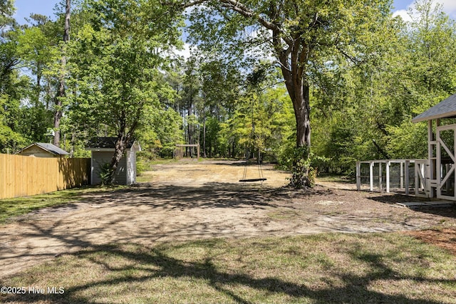 view of yard featuring an outdoor structure and fence