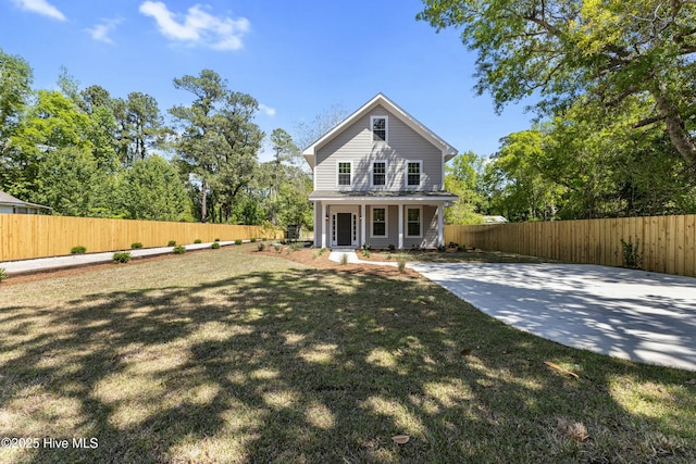 back of house featuring a yard, fence private yard, and covered porch