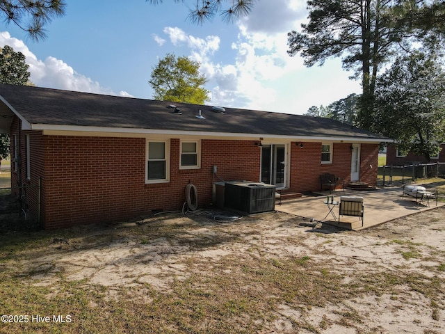 back of property featuring brick siding, central AC, fence, and a patio area