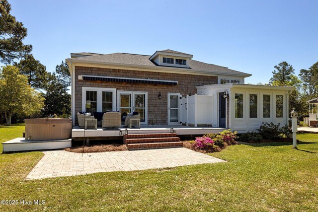 back of property featuring a deck, a yard, a hot tub, and a patio