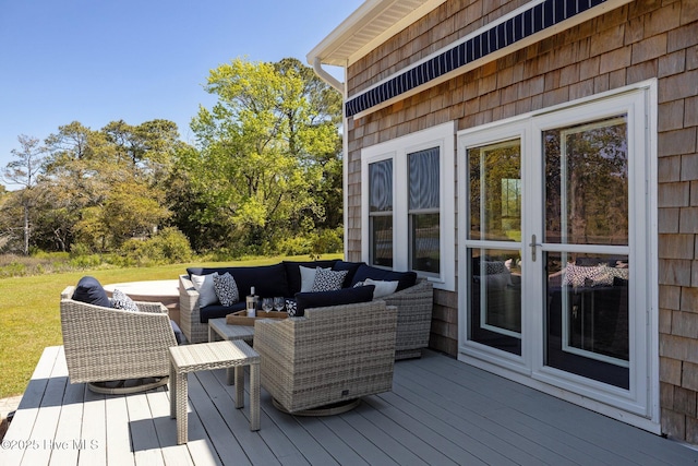 deck with an outdoor living space and a yard