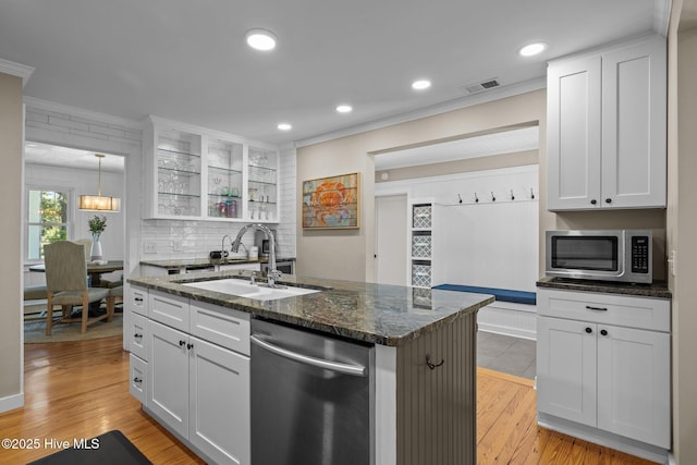 kitchen featuring tasteful backsplash, a sink, appliances with stainless steel finishes, light wood-style flooring, and ornamental molding