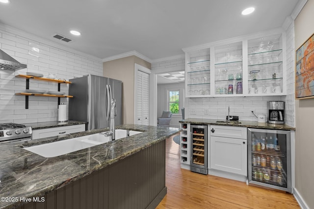 bar featuring stainless steel appliances, visible vents, beverage cooler, and wet bar