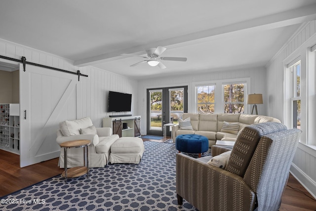 living room featuring a barn door, beamed ceiling, wood finished floors, and ceiling fan