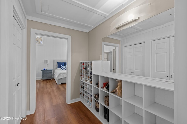 hall with attic access, baseboards, and wood finished floors