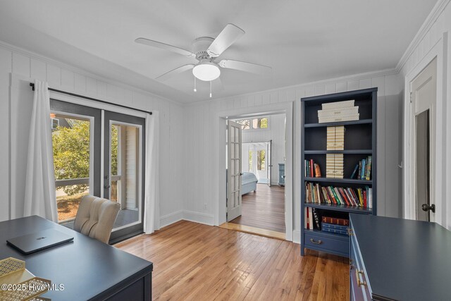 office space featuring a ceiling fan, crown molding, french doors, and light wood-type flooring