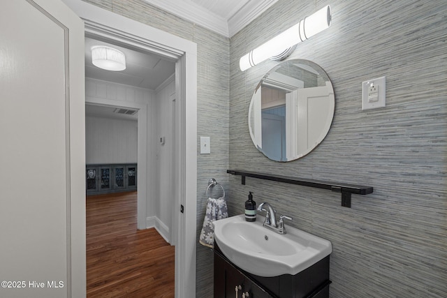bathroom featuring crown molding, wood finished floors, vanity, baseboards, and visible vents