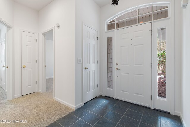 1710 Bay Tree Ct SW, Ocean Isle Beach, NC 28469 - entryway with dark tile patterned flooring, baseboards, and dark colored carpet