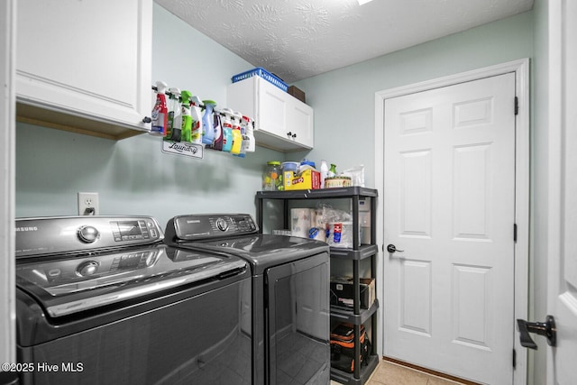 washroom featuring cabinet space, separate washer and dryer, and light tile patterned flooring