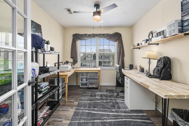 office featuring dark wood-style flooring, visible vents, and ceiling fan