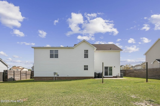 rear view of property featuring a fenced backyard and a lawn