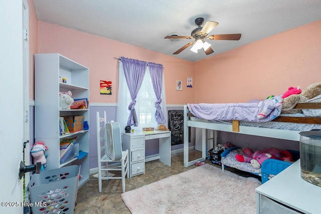 bedroom with a wainscoted wall and ceiling fan