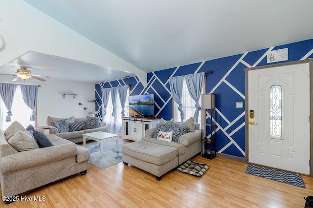 living area featuring ceiling fan, wood finished floors, a healthy amount of sunlight, and lofted ceiling