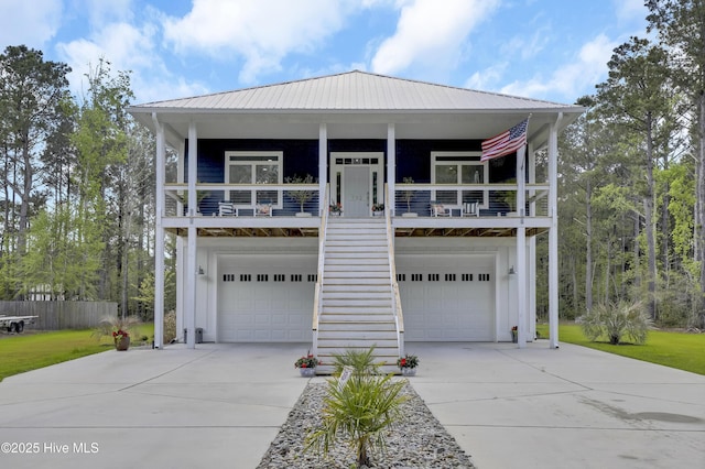 732 Avila Ave, Hampstead, NC 28443 - beach home featuring concrete driveway, an attached garage, board and batten siding, metal roof, and covered porch