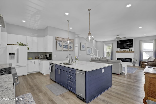 732 Avila Ave, Hampstead, NC 28443 - kitchen with a sink, appliances with stainless steel finishes, white cabinets, a ceiling fan, and a glass covered fireplace