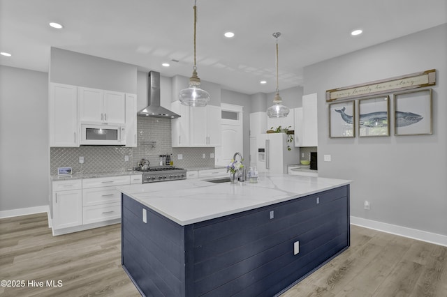 732 Avila Ave, Hampstead, NC 28443 - kitchen with wall chimney exhaust hood, white appliances, a sink, white cabinetry, and light wood finished floors