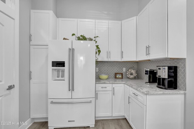 732 Avila Ave, Hampstead, NC 28443 - kitchen featuring white refrigerator with ice dispenser, light wood-style floors, and white cabinets