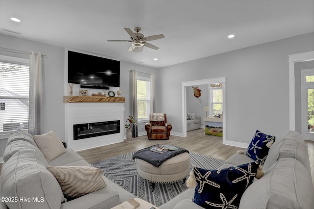 732 Avila Ave, Hampstead, NC 28443 - living room with ceiling fan, plenty of natural light, wood finished floors, a glass covered fireplace, and recessed lighting
