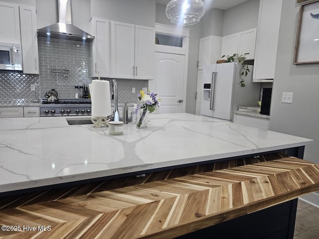 732 Avila Ave, Hampstead, NC 28443 - kitchen with wall chimney range hood, high end white refrigerator, white cabinets, and tasteful backsplash
