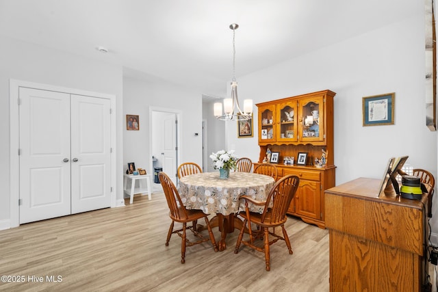 dining space featuring light wood-style flooring and an inviting chandelier