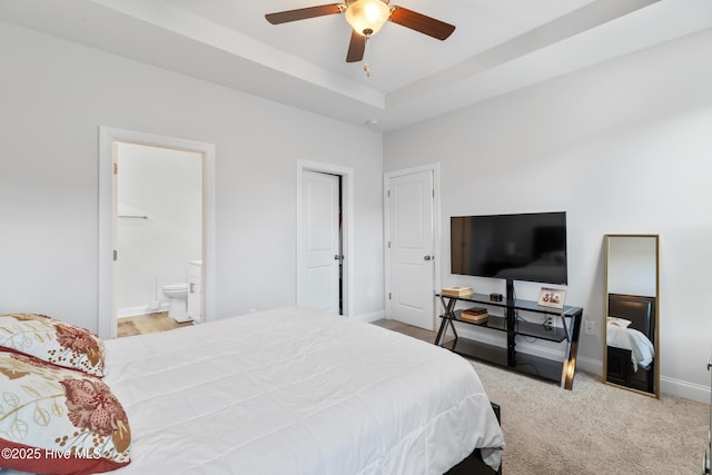bedroom featuring connected bathroom, a ceiling fan, carpet flooring, a raised ceiling, and baseboards