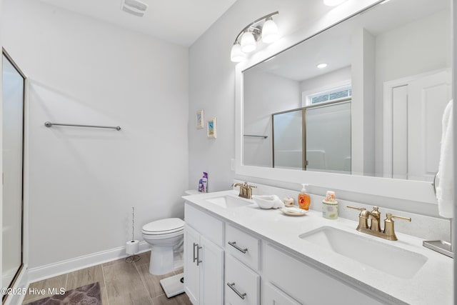 full bath with a sink, toilet, double vanity, and a stall shower