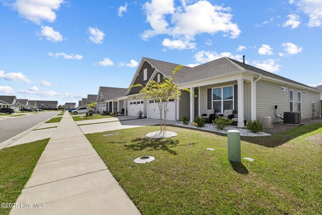 view of side of property with a residential view, central air condition unit, a yard, a shingled roof, and driveway