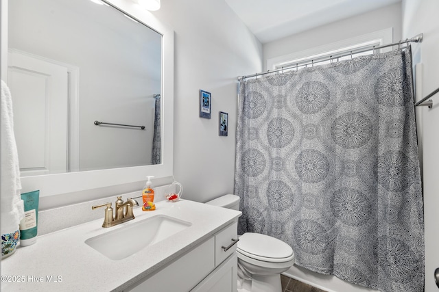 bathroom featuring toilet, vanity, and a shower with curtain