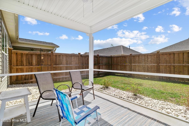 wooden terrace with a fenced backyard and a lawn