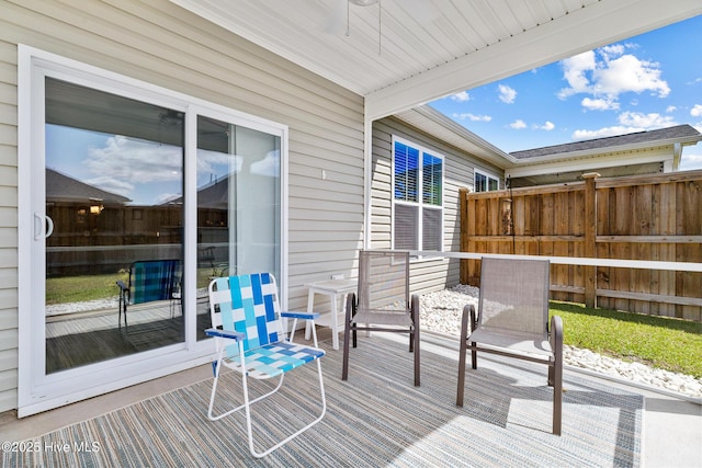 wooden terrace with fence and a ceiling fan