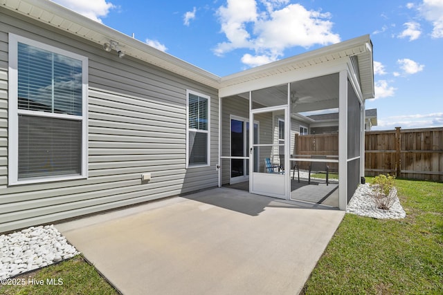 view of patio featuring fence and a sunroom