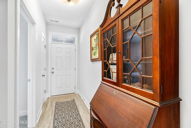 entryway featuring light wood-type flooring, baseboards, and visible vents