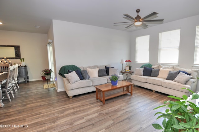 living room with baseboards, wood finished floors, and a ceiling fan