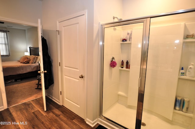 bathroom with a shower stall, ensuite bath, and wood finished floors