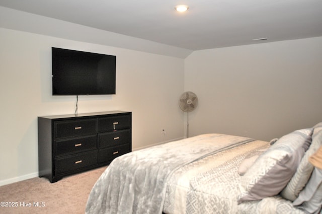 bedroom featuring vaulted ceiling, baseboards, and light colored carpet