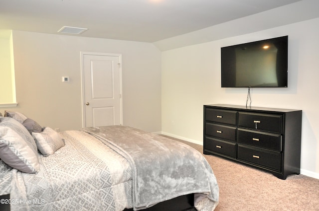 bedroom featuring light colored carpet, vaulted ceiling, and baseboards