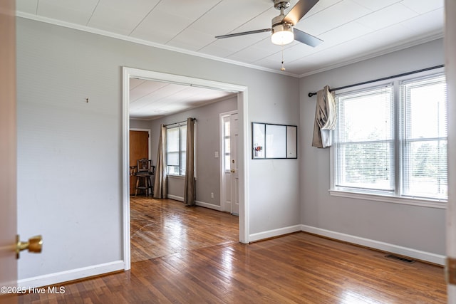 spare room with visible vents, baseboards, ceiling fan, ornamental molding, and hardwood / wood-style floors