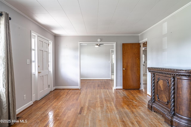 entryway with hardwood / wood-style flooring, baseboards, and crown molding