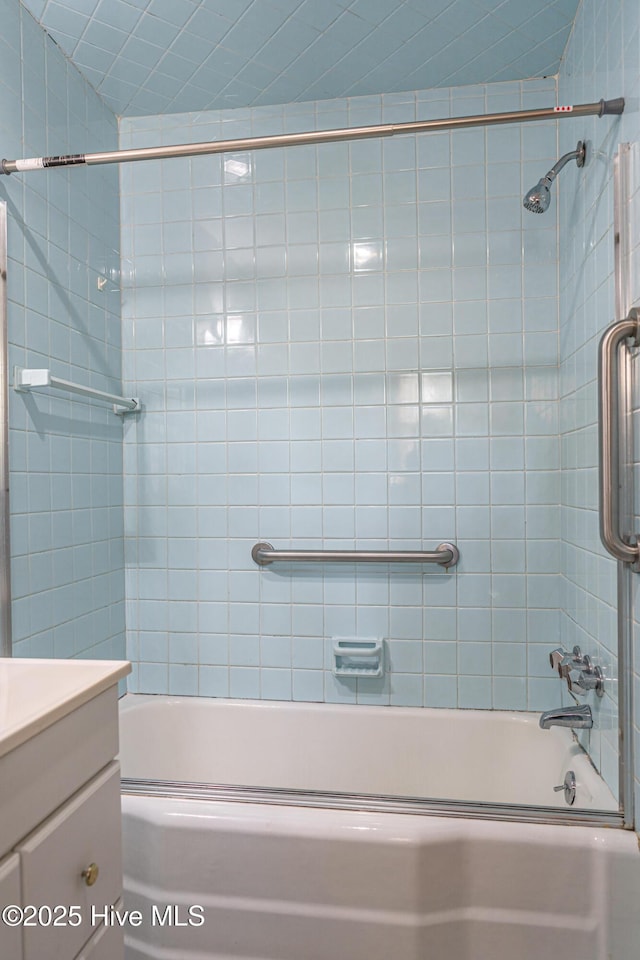 bathroom featuring vanity and enclosed tub / shower combo