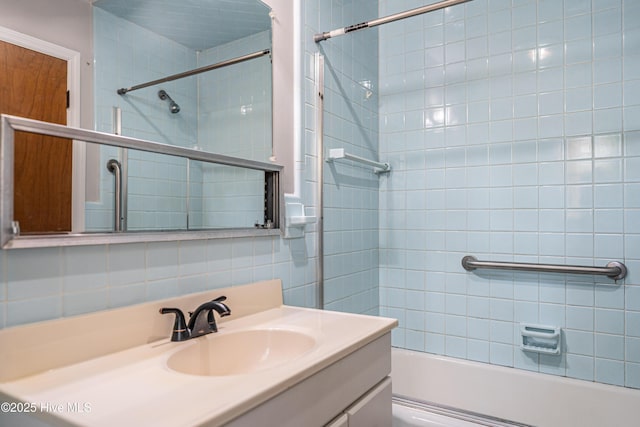 bathroom with vanity, tasteful backsplash, and bath / shower combo with glass door