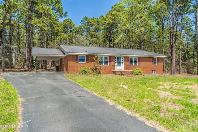 single story home with a front yard, a carport, brick siding, and aphalt driveway
