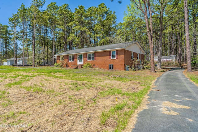 view of front of home featuring driveway and brick siding