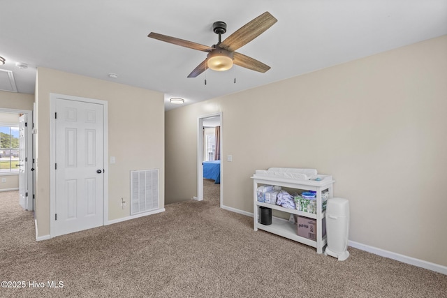 rec room with a ceiling fan, visible vents, attic access, carpet flooring, and baseboards