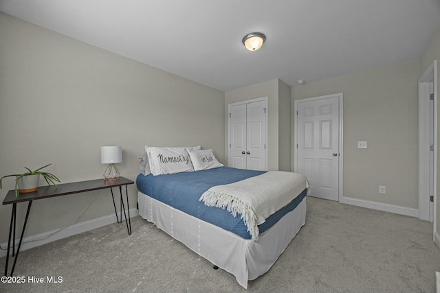 carpeted bedroom featuring a closet and baseboards