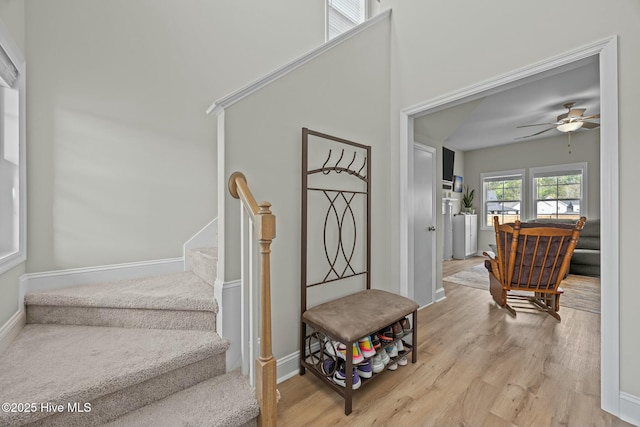 stairway featuring ceiling fan, wood finished floors, and baseboards