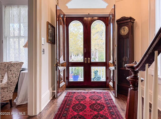 foyer entrance with plenty of natural light, baseboards, wood finished floors, and french doors