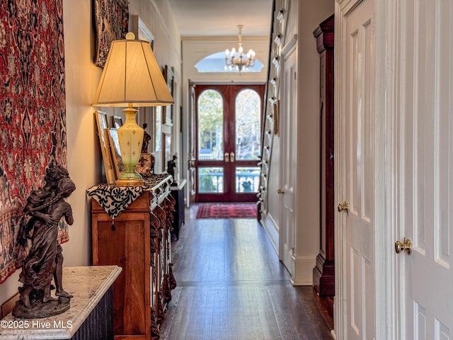entrance foyer with dark wood finished floors, baseboards, and a notable chandelier